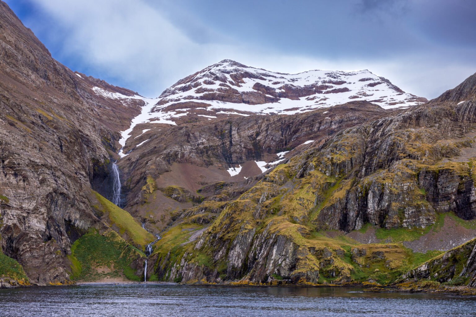 Hercules Bay Waterfall. A view of the tall mountains with a waterfall.
